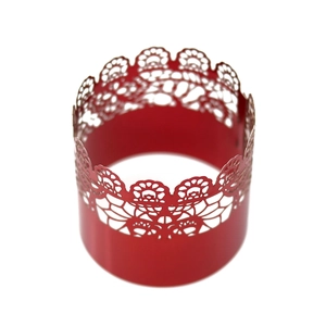 Macro detail of red laser-cut lace floral pattern napkin ring for festive table decor