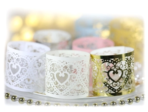 Detail of laser-cut heart napkin rings in pearl white, cream, gold, and pink paper