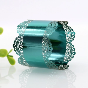 Macro shot of teal napkin ring featuring intricate laser-cut lace pattern and glossy finish