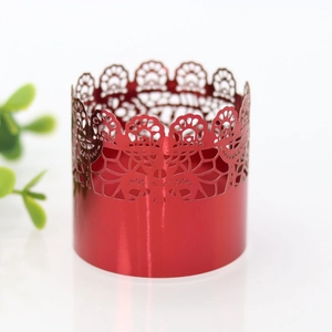 Detail of red metallic lace cupcake wrapper with intricate laser-cut floral patterns