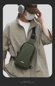 Outdoor shot of army green nylon chest bag with MACHUGE label and durable shoulder strap