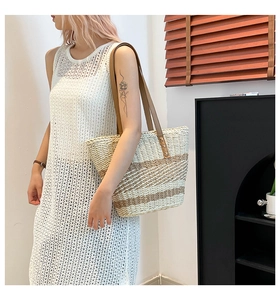 Detail of woven straw tote with brown leather straps and chic striped texture pattern