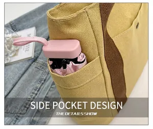 Detail of canvas tote bag side pocket holding a small folding umbrella for daily use