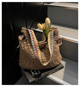 Dettaglio borsa in paglia intrecciata a mano con trama floreale 3D e tracolla etnica