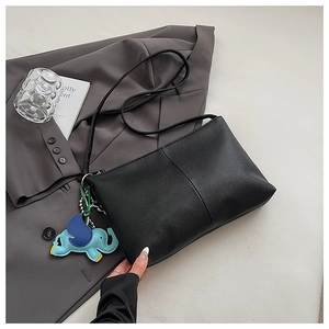 Detail of black lychee leather tote bag featuring a cute elephant charm for office commute