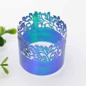 Close-up of laser-cut napkin rings with iridescent blue-purple gradient and leaf patterns