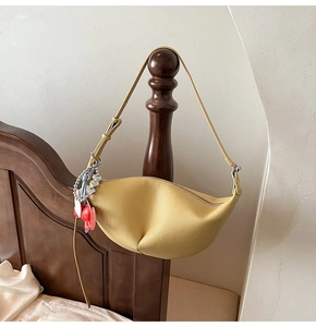 Yellow pebble leather half-moon bag with adjustable strap and colorful heart charm