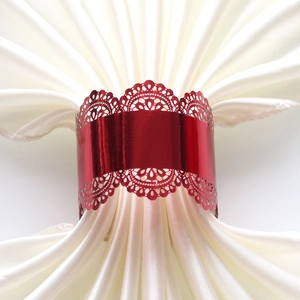 Close-up of red metal napkin ring with lace cutout edges and white satin napkin decoration
