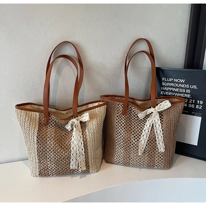 Détail de sacs cabas en paille tressée avec nœuds en dentelle et anses en cuir marron