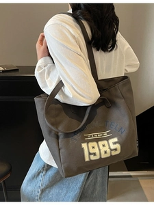 Sac fourre-tout en toile gris foncé avec imprimé 1985 porté par un mannequin