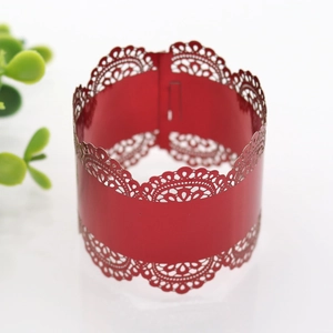 Detail of red laser-cut lace napkin ring with intricate floral pattern for weddings