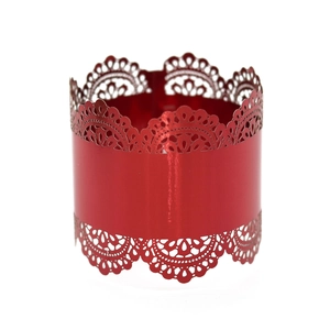 Close-up of laser-cut red napkin ring featuring intricate lace patterns and shiny metallic finish