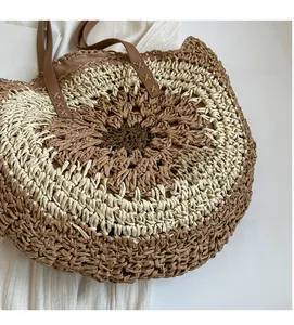 Top-down view of woven straw tote bag texture with brown leather strap and spiral pattern