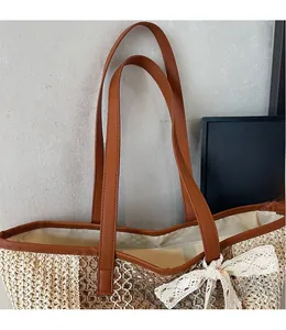 Détail d'un sac cabas en paille tressée avec couleurs contrastées et nœud en dentelle