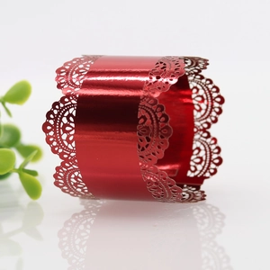 Detail of red laser-cut lace napkin ring with metallic luster and floral hollow pattern