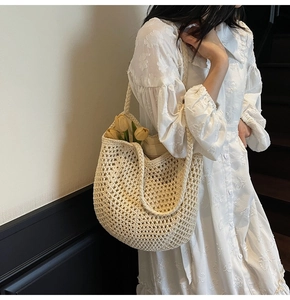 Detail of hand-woven beige tote bag with intricate floral patterns and cotton texture
