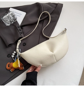 Detail of beige lychee texture dumpling bag with a cute leather elephant charm