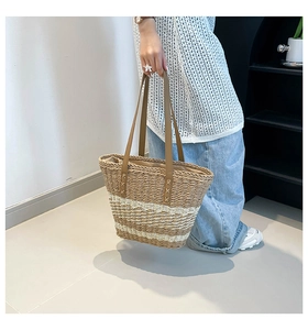 Detail of hand-woven striped beach tote with leather handles and reinforced stitching