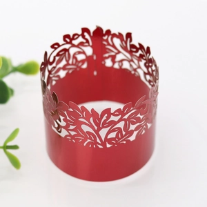 Detail of red laser-cut napkin ring with intricate leaf pattern for festive events