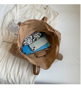 Detailed view showing the spacious interior and zipper pocket of this woven straw beach bag