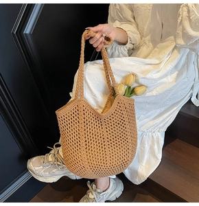 Detail of hand-woven straw tote bag with hollow mesh pattern for summer beach vacations