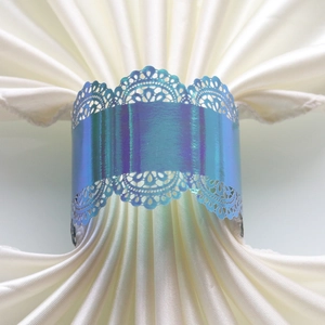 Close-up of laser-cut iridescent blue lace napkin ring for wedding and party tables