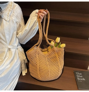 Close-up of beige crochet woven tote bag with hollow mesh pattern and braided strap detail