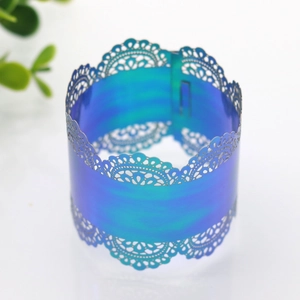Detail of laser-cut lace floral napkin ring in gradient blue-green pearlescent paper