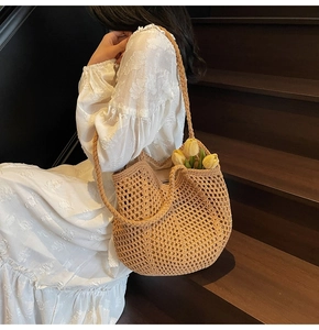 Detail of beige hand-woven crochet mesh tote bag featuring a thick shoulder strap and pattern