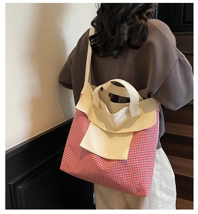 Detail of red and white checkered canvas tote bag with cream shoulder straps