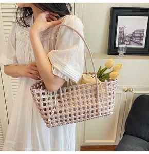 Detailopname van roze geweven tote tas met beige trekkoord binnenzak gedragen door model