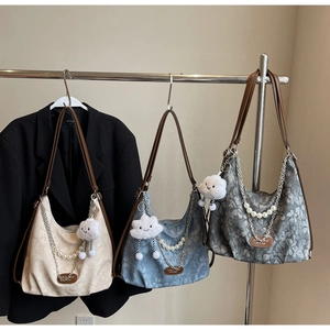 Detailed view of floral jacquard hobo bags with silver chains and pearl charms