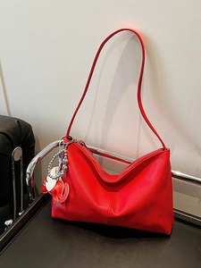 Chic red lychee leather tote bag with elephant charm and adjustable shoulder strap