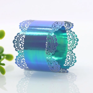 Macro detail of laser-cut lace napkin ring with iridescent blue-purple gradient finish
