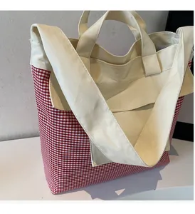 Detail of red and white checkered canvas tote bag with reinforced handles for women