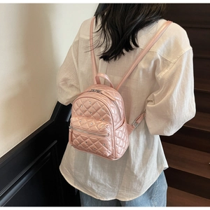 Detail of pink quilted mini backpack featuring silver rhinestones and glossy finish