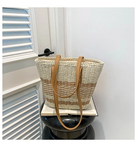 Detailed macro view of cream and brown striped woven tote bag with leather straps