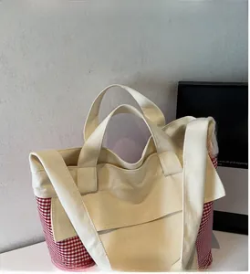 Close-up of red and white checkered canvas tote bag with durable stitching and wide handles