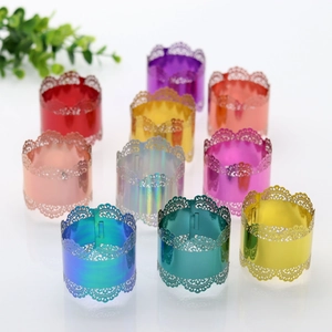 Detail view of hollow lace napkin rings in various vibrant metallic colors for weddings