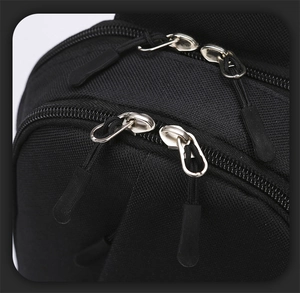 Detail of durable metal dual zippers and nylon fabric on black tactical sling bag