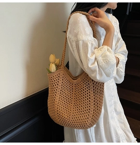Detail of hand-woven hollow brown tote bag showing intricate crochet texture and long strap