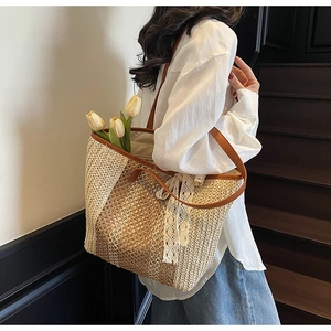 Détails du sac cabas en paille avec bandoulière en cuir et nœud décoratif en dentelle