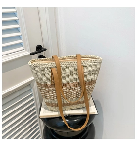 Close-up of color-block woven tote bag with brown leather handles and striped texture