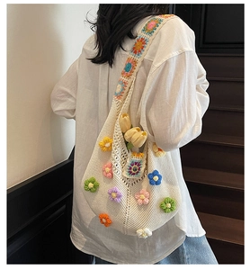 Detail of white crochet shoulder bag featuring colorful handmade 3D floral embroidery