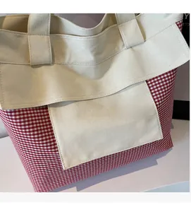 Detail of red and white checkered canvas tote bag with spacious front pocket