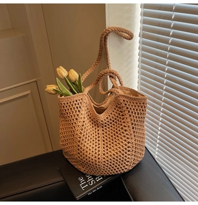 Detail of khaki woven tote bag showing hollow crochet honeycomb texture and double handles