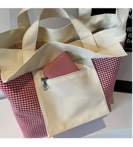Detail of red and white checkered canvas tote bag interior with functional zipper pocket