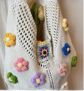 Close-up of white knitted tote bag with colorful 3D crochet flowers and tulip decor