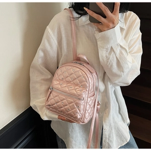 Detailed shot of pink quilted mini backpack featuring rhinestones and glossy PU leather