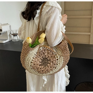 Close-up of handmade woven straw tote bag featuring bohemian concentric circle patterns
